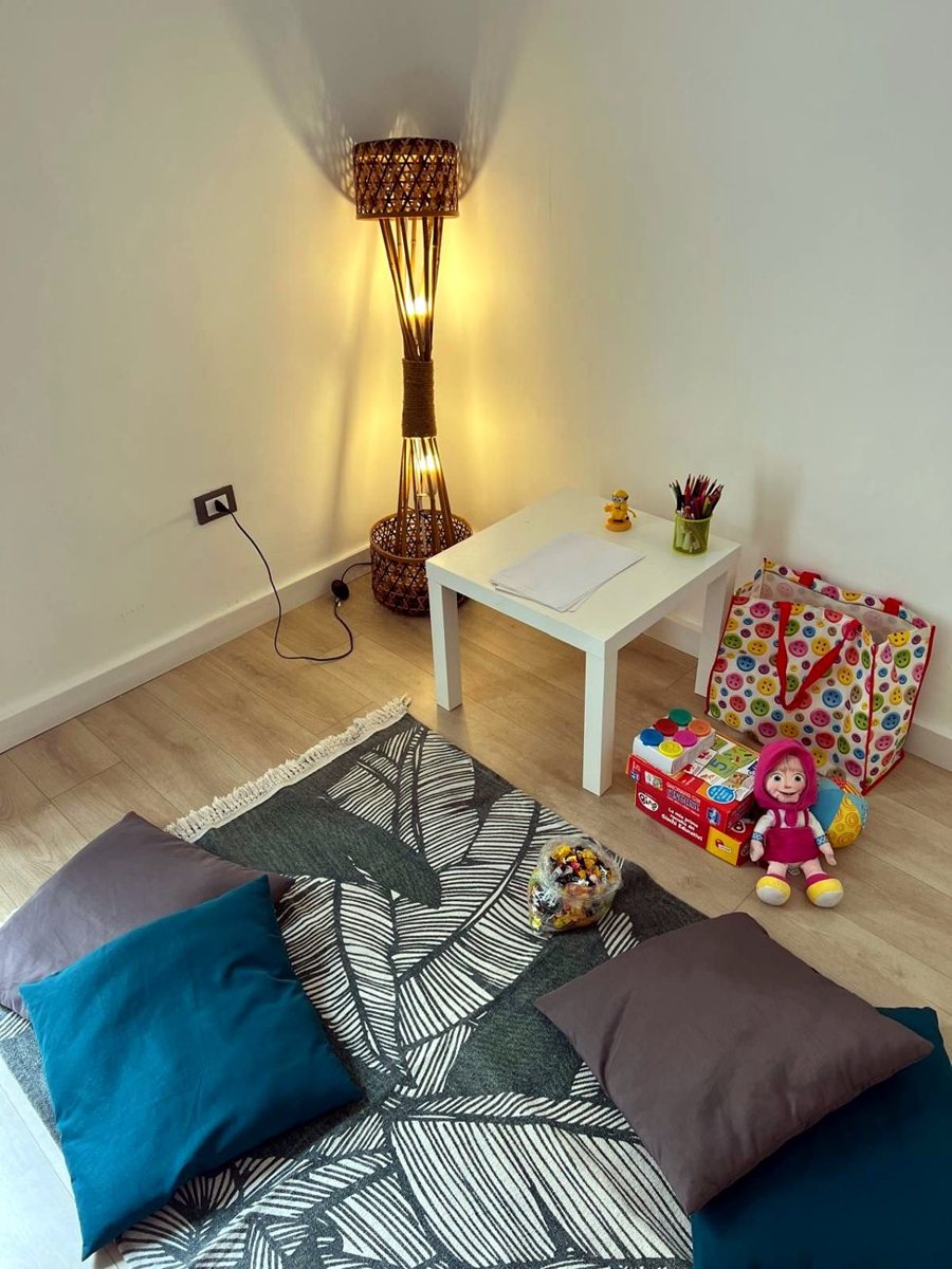 Un angolo accogliente dello studio, con lampada calda e cuscini